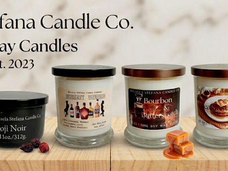 Hand-poured soy candles by Micaela Stefana Candle Co. on a wooden table.