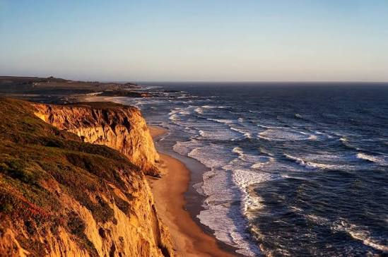 A gorgeous California coastline, including cliffs, the ocean, and golden light.