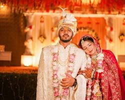 Newlyweds in traditional attire pose at their vibrant Indian wedding.