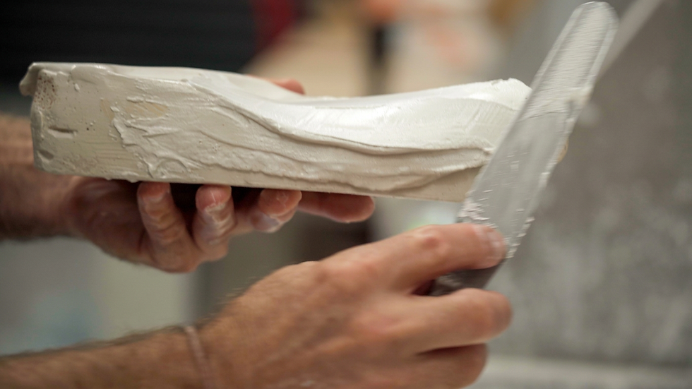 closeup of crafting a plaster mould with spatula