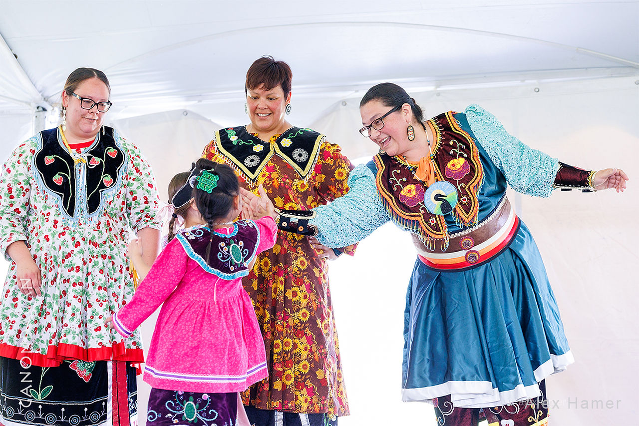 Hauenosaunee women interacting with a child performer