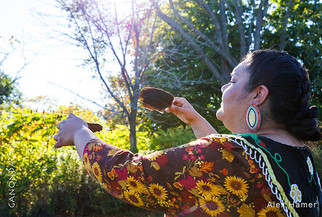 Seneca woman holding a shell and feather