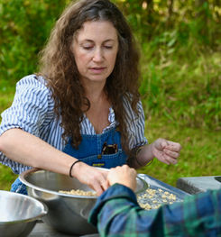People at picnic table outside with bowls set on table