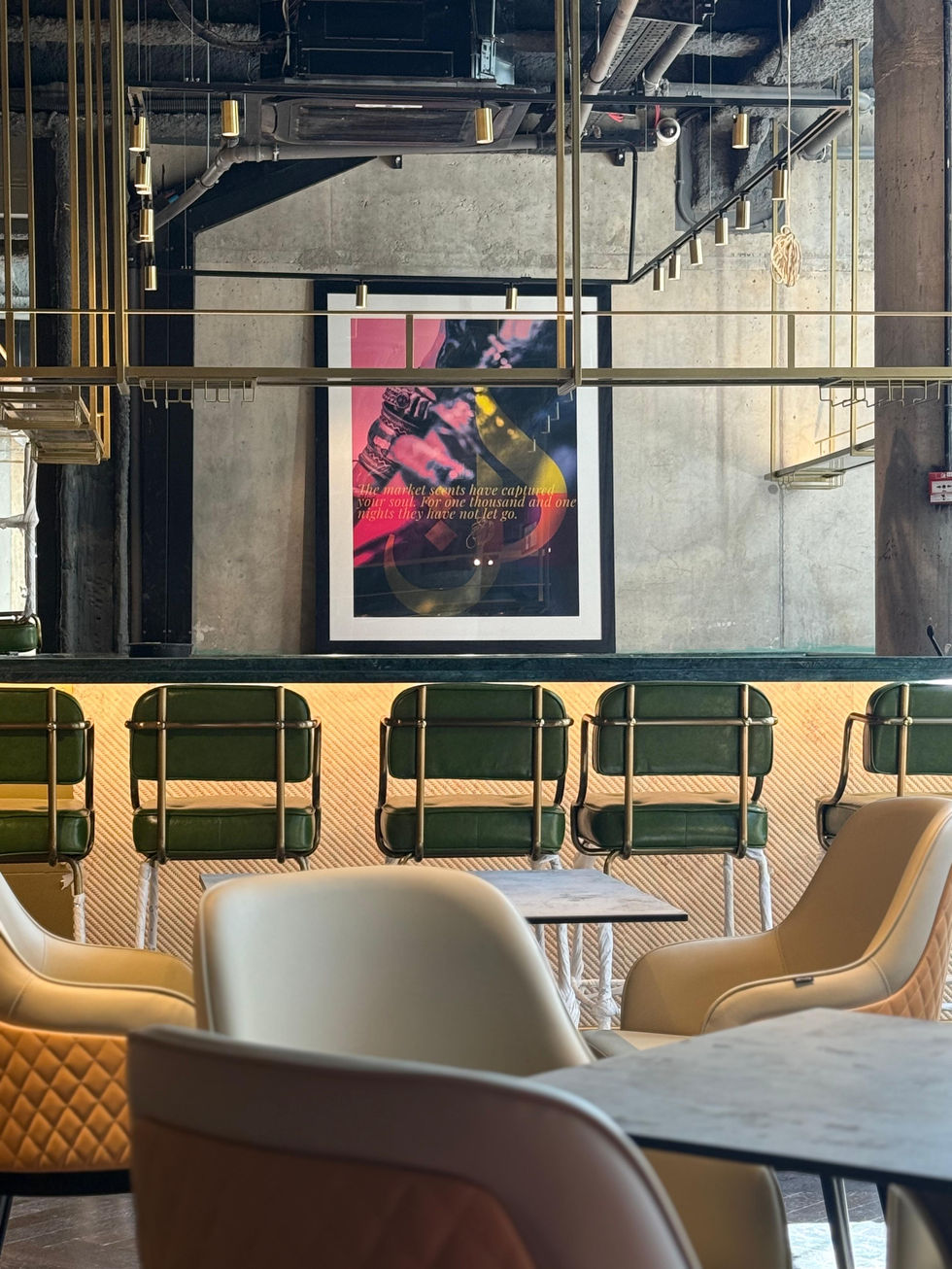 Bar seating with abstract art, green and gold chairs, and a modern décor setting.