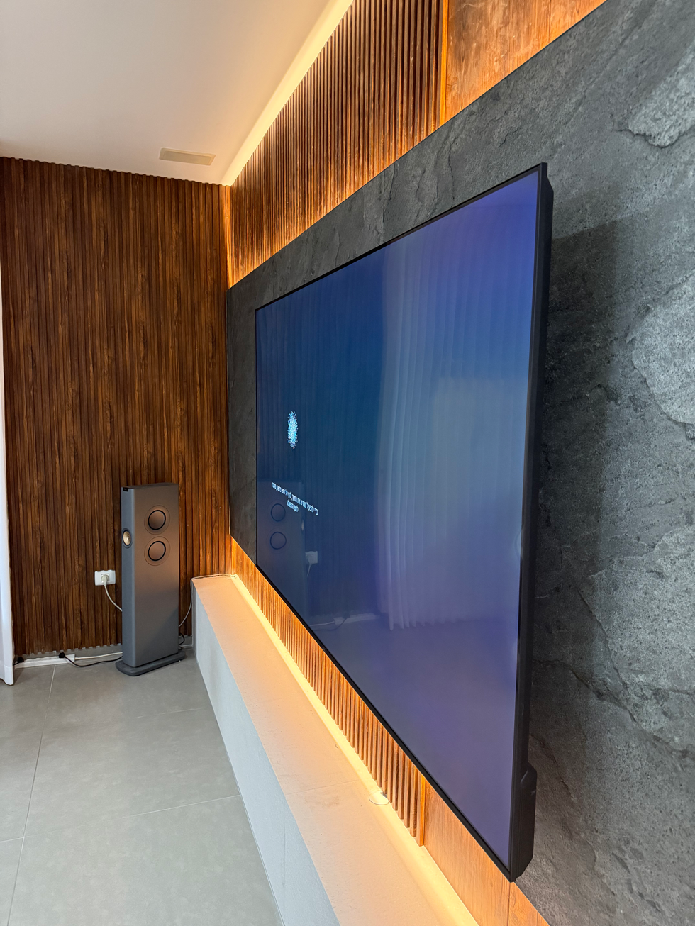 Large TV screen on stone wall, wooden paneling, and modern interior design
