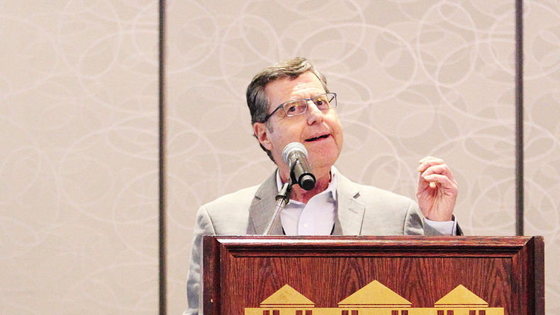 Harvey Cooper speaking at a podium