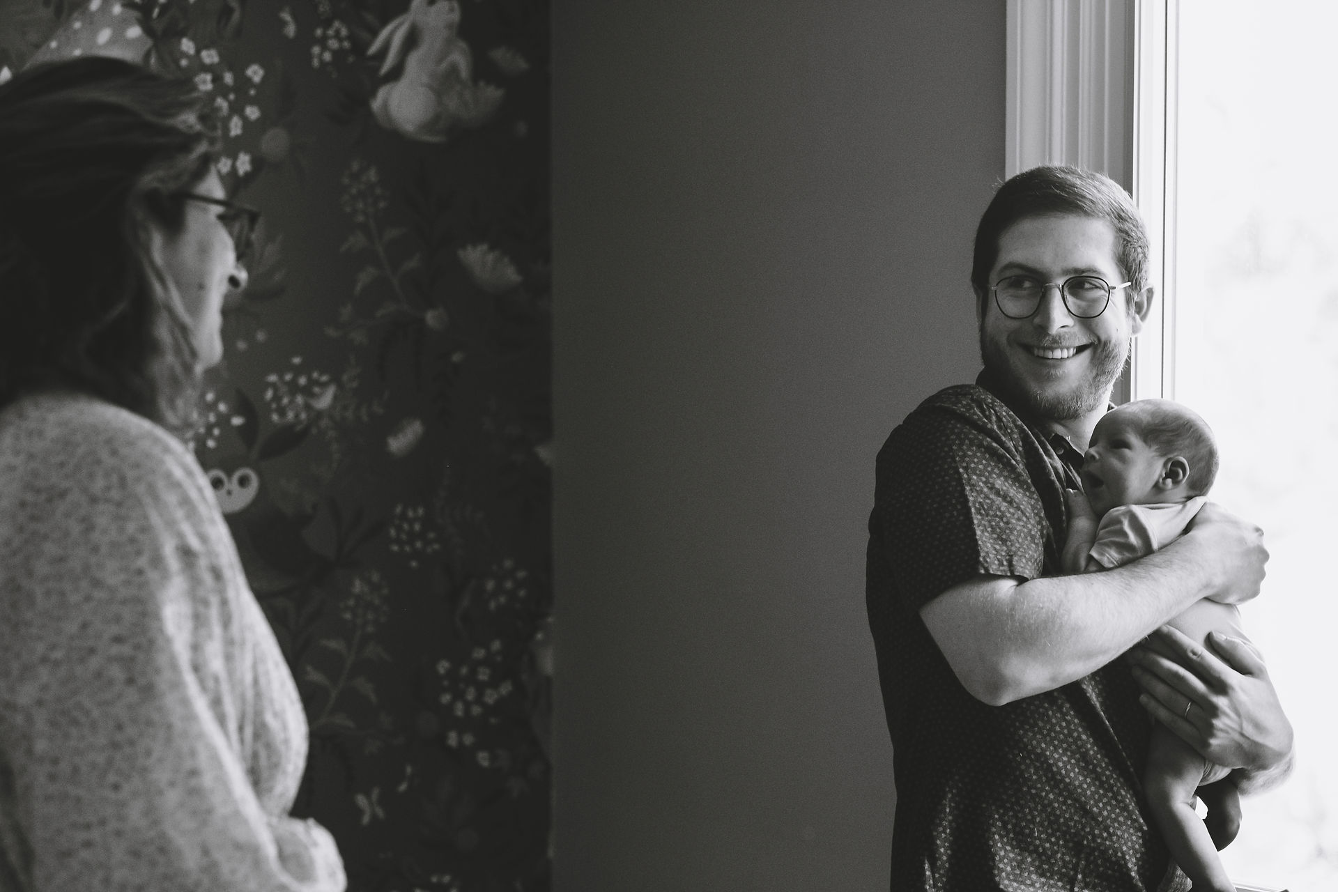 New parents with their newborn baby boy during in-home photo session with Melanie Mathieu Photography. Melanie is a family documentary and lifestyle photographer in Ottawa Gatineau.