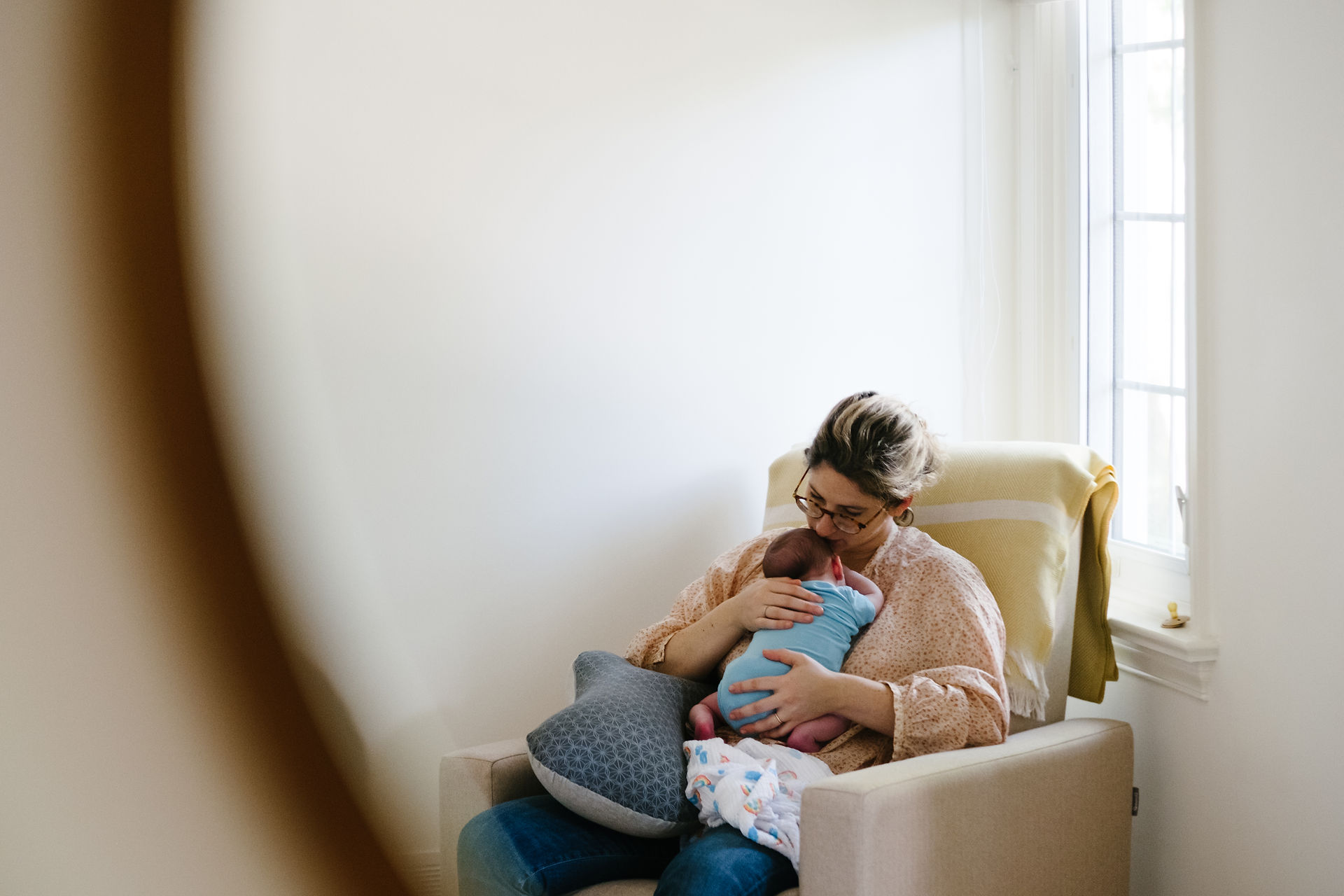 Mother kissing newborn baby boy during in-home, newborn, candid, lifestyle photography session. Melanie Mathieu is an Ottawa lifestyle and family photographer working in Ottawa Gatineau.