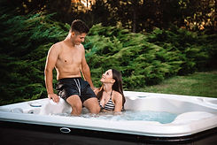 A young couple enjoying a romantic evening in a Hydropool luxury hot tub.