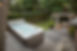 A swim spa set onto the side of a deck, with a pergola and seating on the layer below.