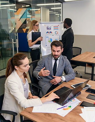 joined-work-two-confident-business-people-formal-suit-working-together-with-laptop-01.jpg