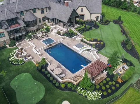 Outdoor Living Space with pool hardscaping, customized kitchen and fire feature in columbus ohio, by Ciminello's Landscaping