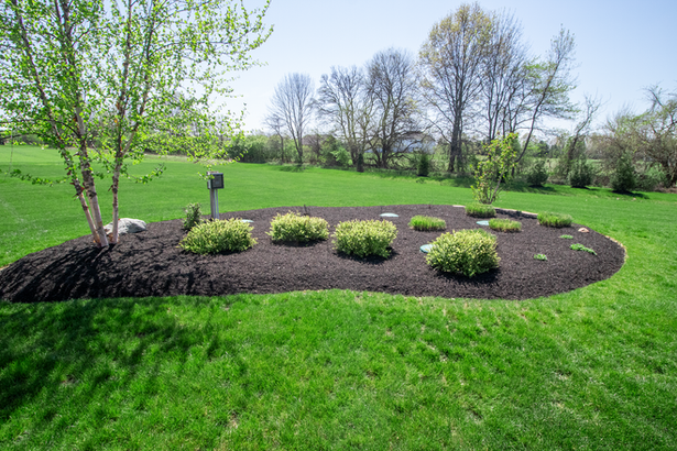 Landscaped garden bed with dark mulch and shrubs in Galena, OH