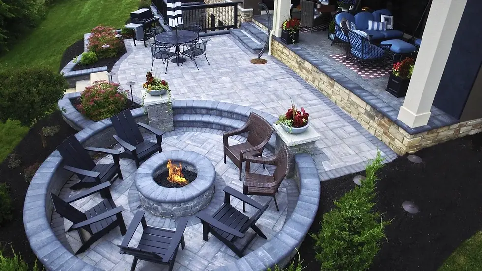 Modern stone patio with fire pit and outdoor seating.