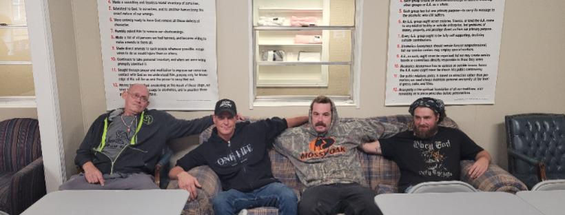 Men in recovery gather on a couch, benefiting from community support and donations to A Vision For You Inc.