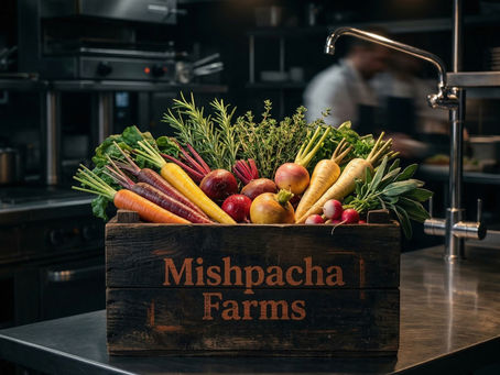 A dark wooden Mishpacha Farms harvest crate resting on a stainless-steel restaurant prep table, overflowing with vibrant, freshly harvested zero-synthetic heirloom produce arriving via direct cold chain.