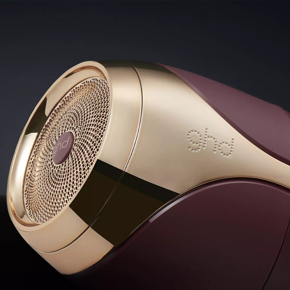Miniaturbild: Nahaufnahme eines ghd Haartrockners mit goldenen Details. ghd Logo sichtbar. HaarPflegeShop.