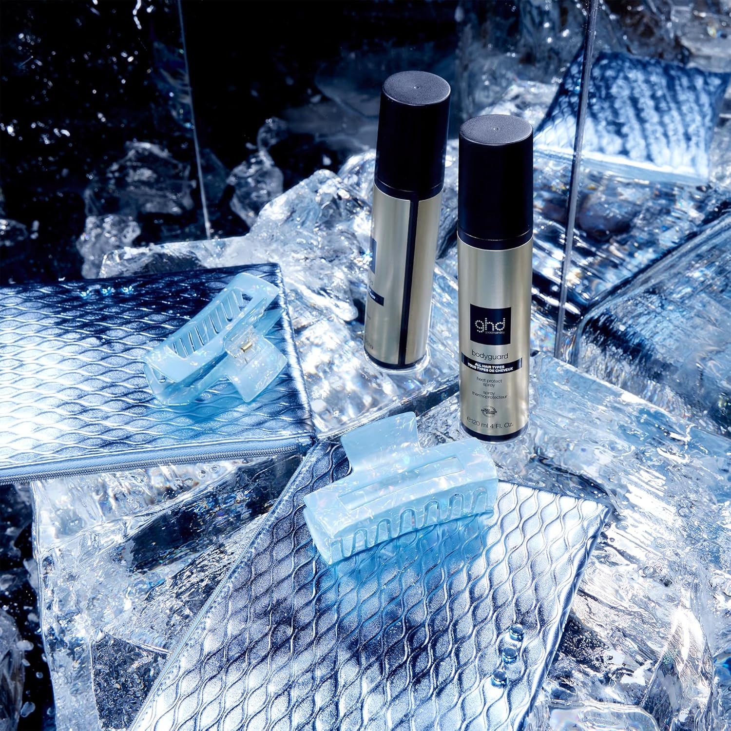 Zwei goldene Haarprodukte und blaue Haarspangen auf Eis, HaarPflegeShop.