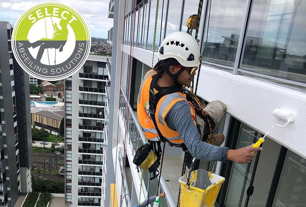 high rise building painting: Rope-access worker in helmet and orange vest paints a white high-rise balcony; Select Abseiling Solutions logo at left.