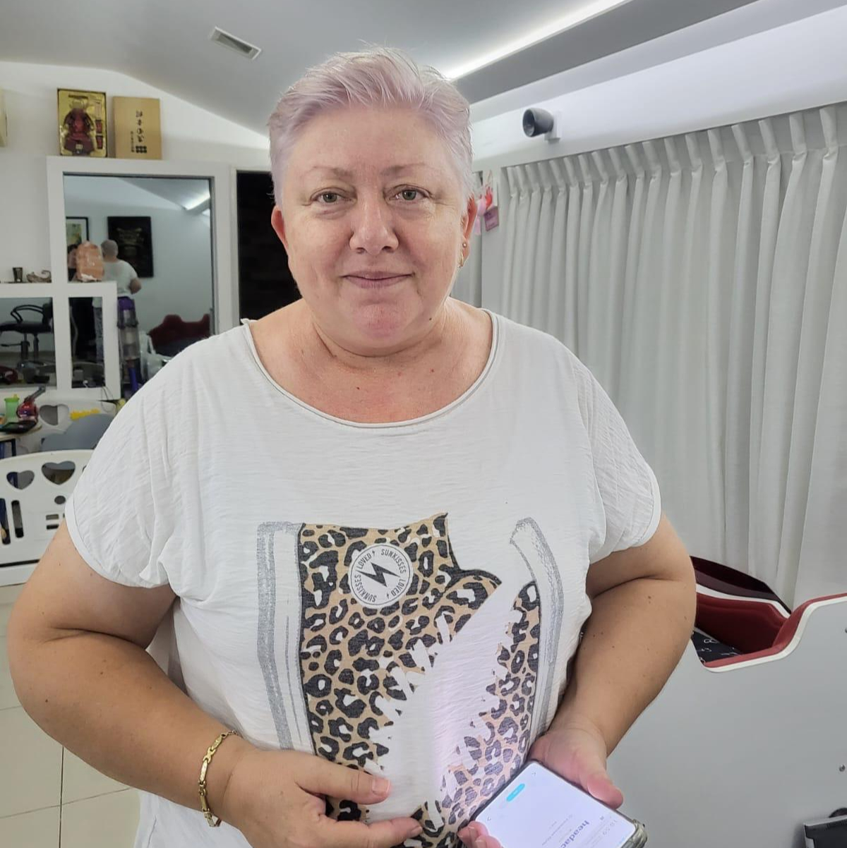 אישה עם שיער קצר בצבע לילך שמה ילנה וגם היא לקוחה של טופ פיש אשר נהנת מהשירות 