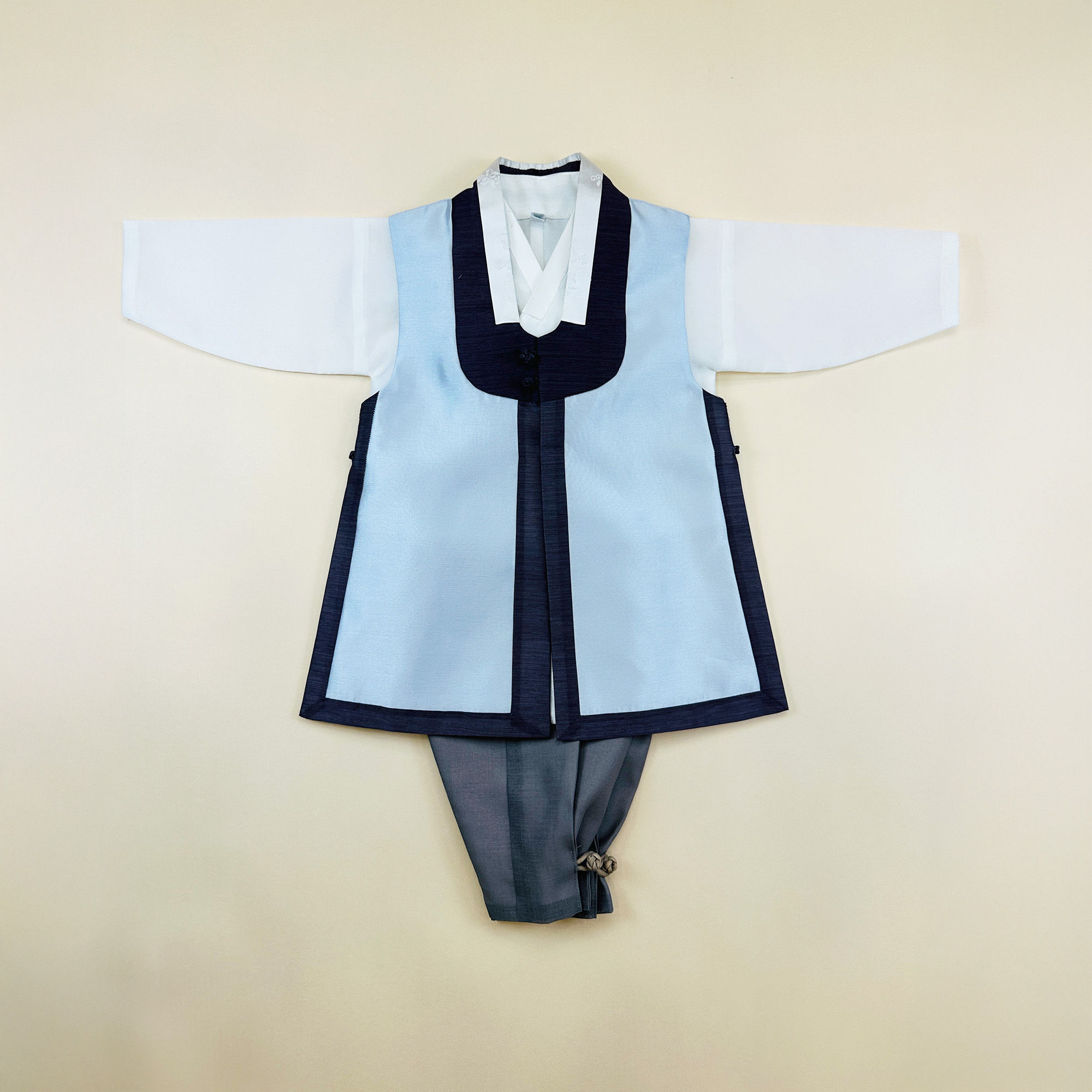 Baby boy dohl hanbok featuring a light blue durumagi-style vest with navy trim, paired with gray pants and white jeogori