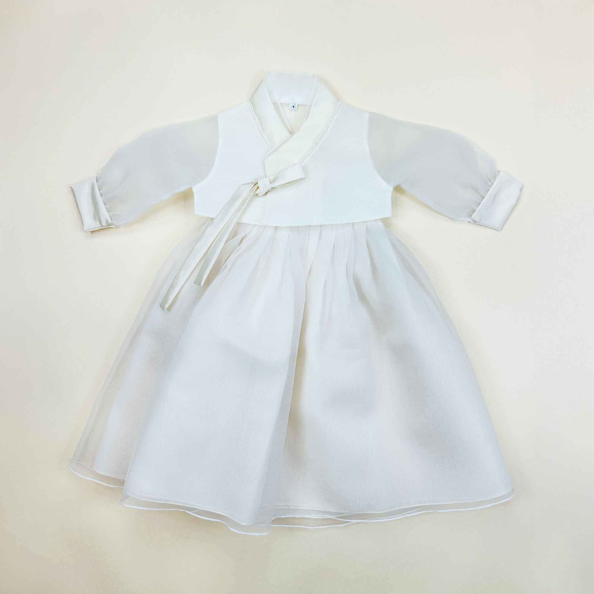 Baby girl hanbok with ivory jeogori and soft blush pink sparkle skirt for first birthday celebration
