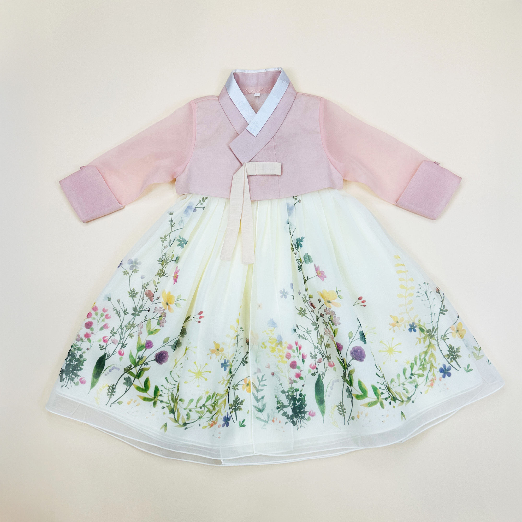 Baby girl hanbok with soft pink jeogori and ivory chima decorated with colorful wildflower print for first birthday celebrati
