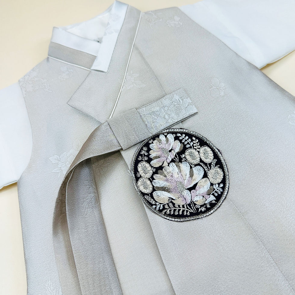 Thumbnail: Baby boy dohl hanbok featuring a light beige floral-patterned vest with embroidered crest, white jeogori, and muted lavender