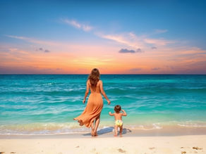 A woman and her child walking on the beach at sunset. Blue sky and teal ocean waters with soft pink clouds. Remembering the power she has inside her.