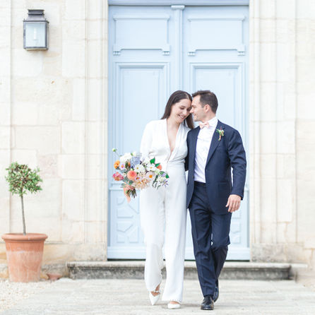 Mariés heureux près d'une porte bleue