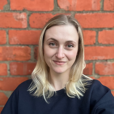 A picture of Melissa against an orange brick wall