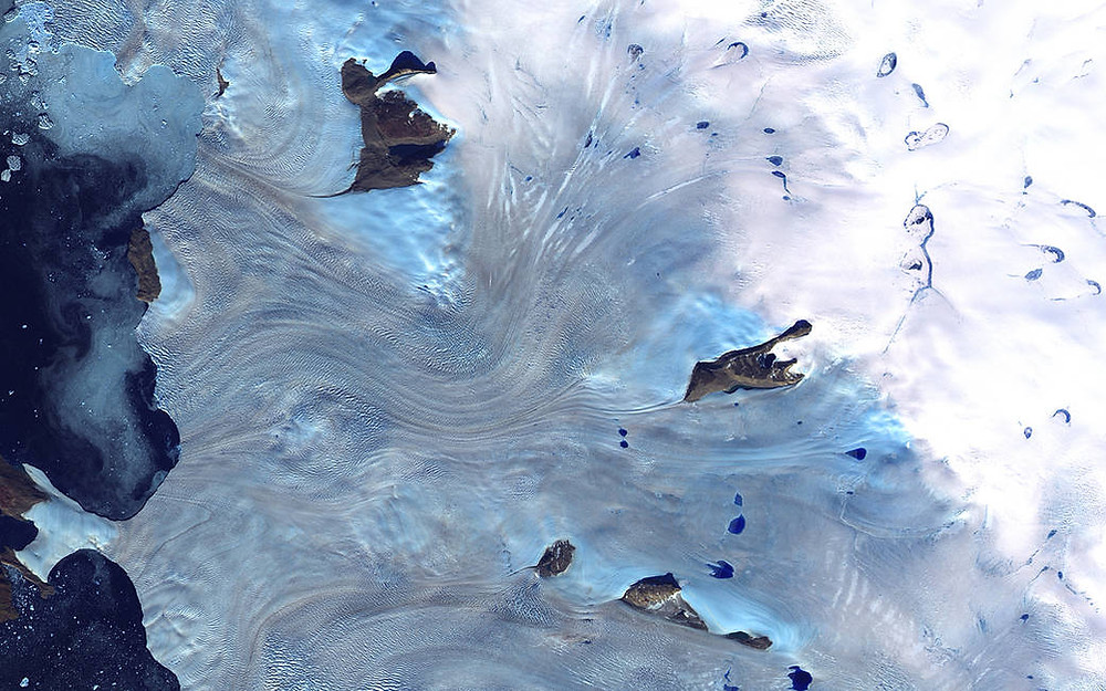 Landsat 7 uydusu tarafından 20 yıldan daha uzun bir süre önce 3 Eylül 2000'de alınan bu görüntü, Grönland'ın batı kıyısı ve Baffin Körfezi'ni çevreleyen küçük buzullar alanına ait. Bu, yakın kızılötesi, kırmızı ve mavi dalga boyları kullanılarak yapılan sahte renkli bir bileşik görüntüdür.
