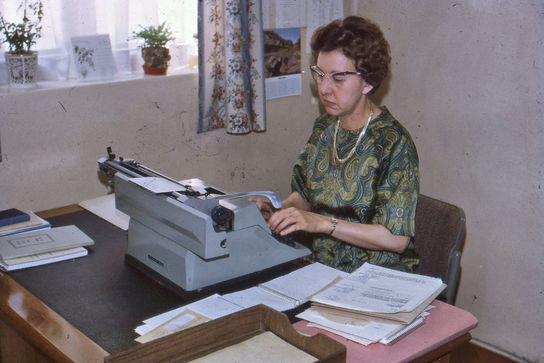 Woman working at a typewriter in an office at Mildmay Hospital.