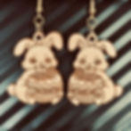 Chocolate-eating bunny earrings against a black background