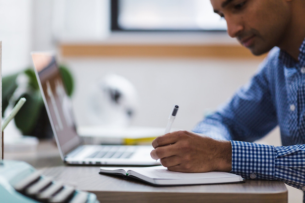 Man sitting at a desk working on his laptop.