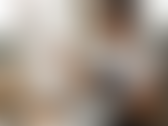 A man painting on an easel in an art studio, holding a brush and a palette.