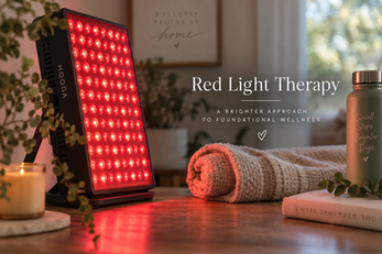 Red light therapy panel glowing in a cozy wellness space with a candle, rolled towel, greenery, and the words “Red Light Therapy” and “A Brighter Approach to Foundational Wellness.