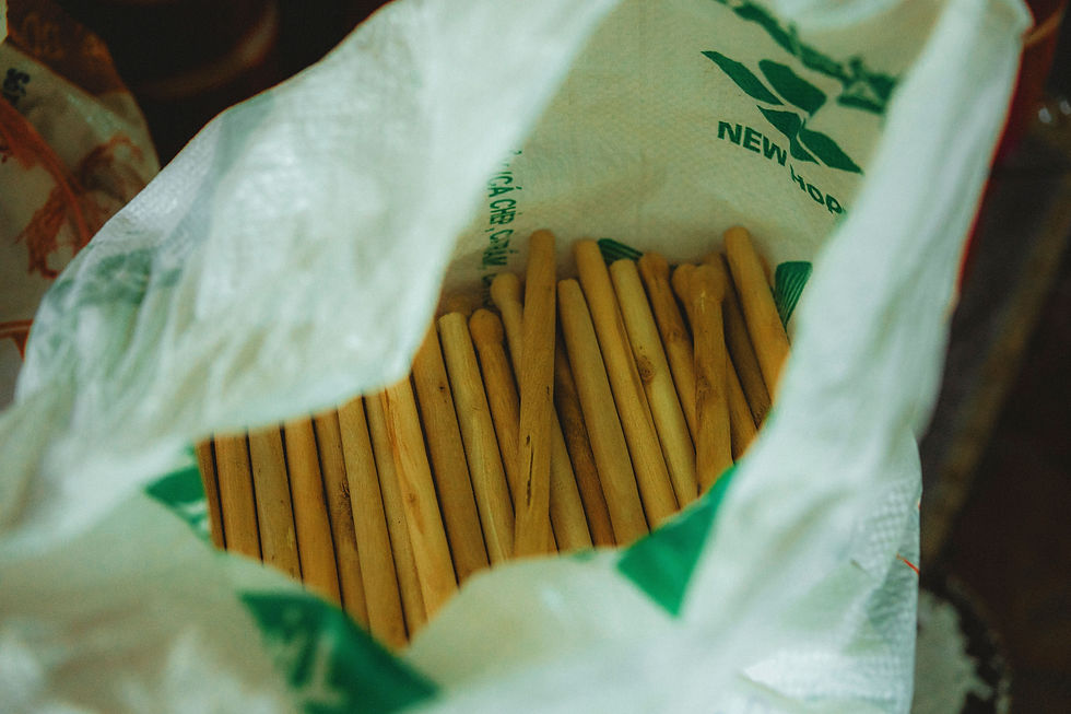 Bețe de lemn într-un sac alb-verde, cu text NEW vizibil, într-o imagine caldă și ușor granuloasă.