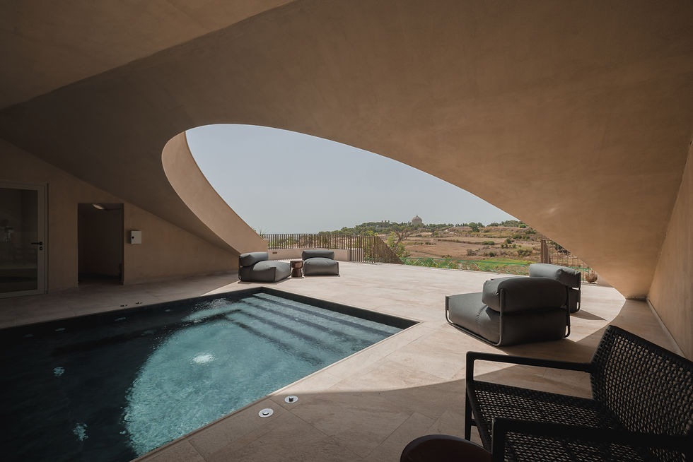 Indoor luxury spa pool at Verdala Wellness and Spa in Malta featuring modern Mediterranean architecture, curved organic ceiling design, natural stone textures, panoramic countryside views, and minimalist lounge seating, creating a serene high-end wellness retreat atmosphere.