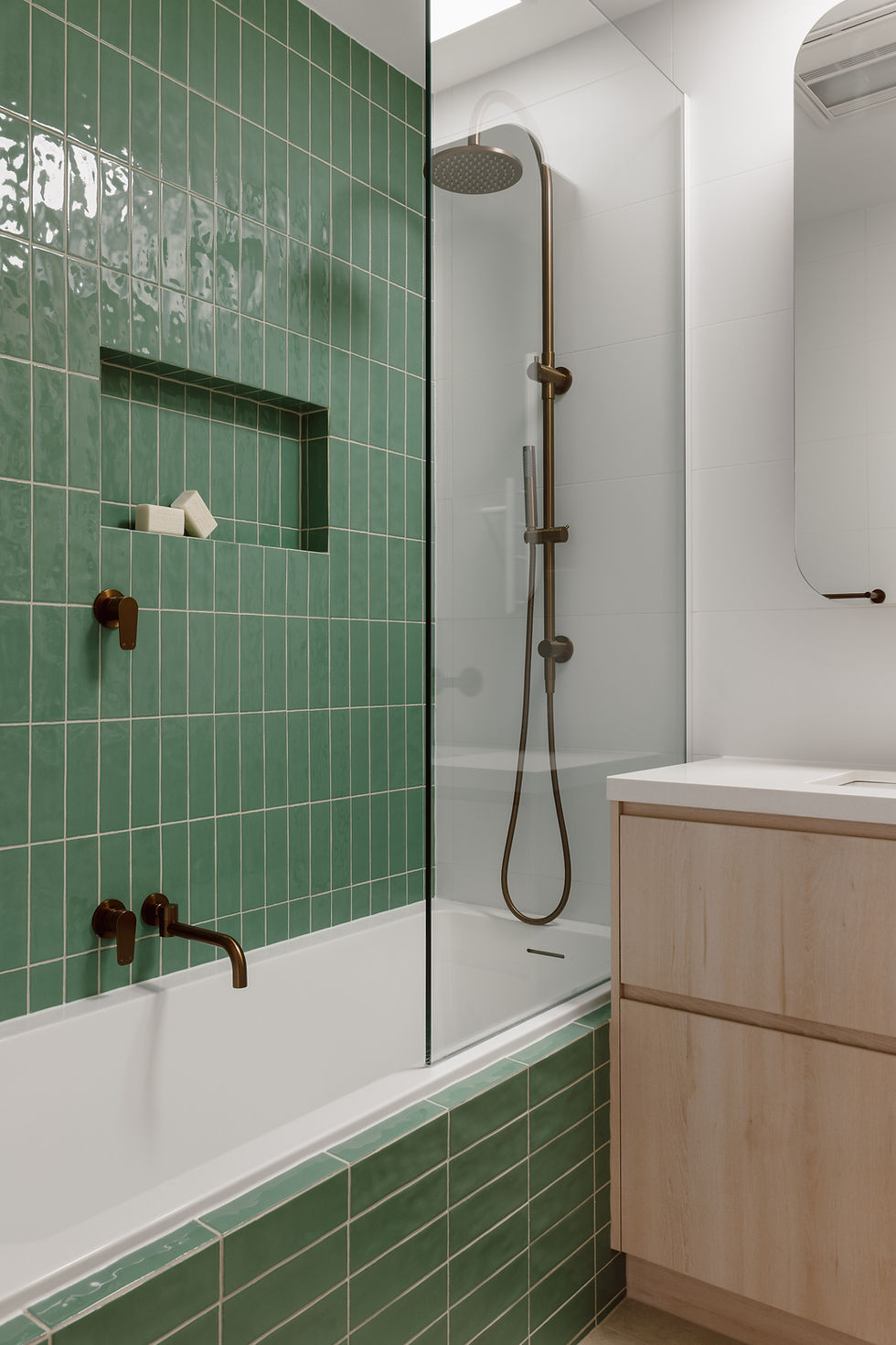 Custom bathroom design with green subway tile feature wall, bronze tapware and Polytec Nordic Oak vanity