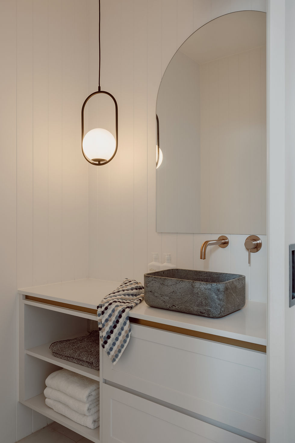 Custom designer powder room with VJ paneling to the walls, a stone basin and a feature pendant