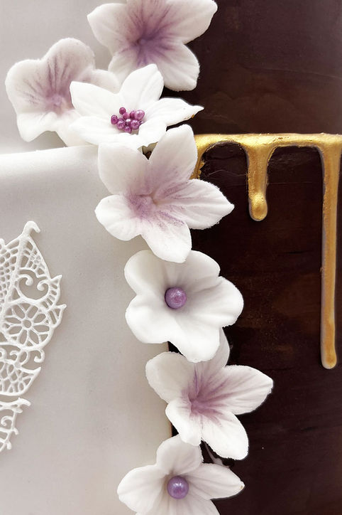Dekorative Hochzeitstorte mit Blüten und Gold