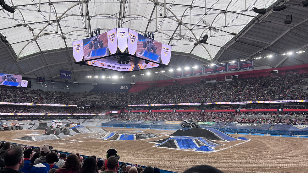 Monster Jam trucks jumping over dirt piles