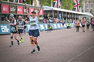 A woman running a marathon cheering with her arms in the air