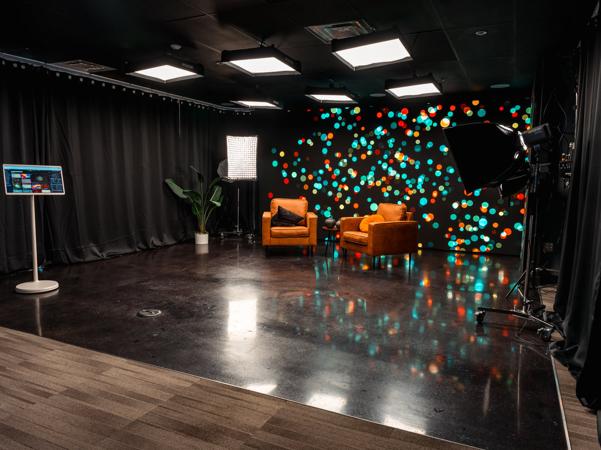 The Disruptor cinema-grade LED wall at MarketScale HQ, lit with a bokeh backdrop behind leather lounge chairs