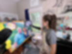 Artist Katie Peña painting a commission oil portrait of a happy couple in her studio in Raleigh, NC