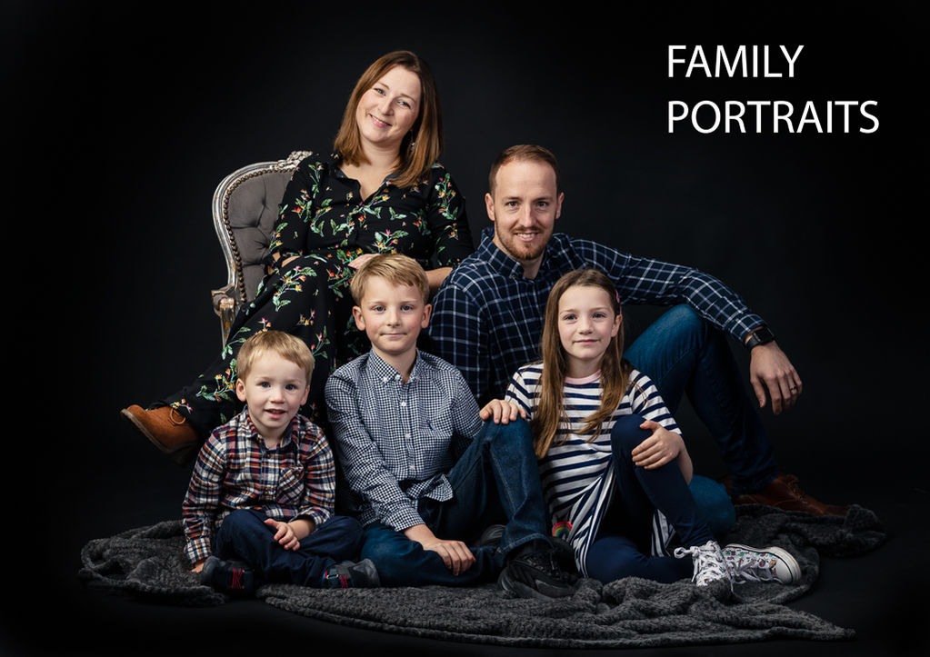 A family recline in the studio on a black background