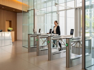 Pessoa entrando de forma fluida por catracas com leitores faciais, representando uma boa experiência do usuário no acesso em ambientes compartilhados.