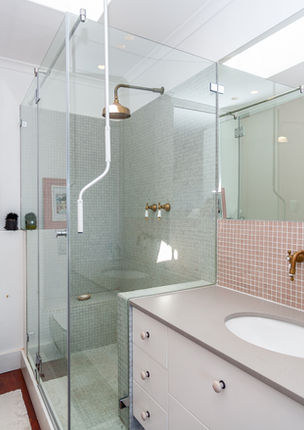 Modern bathroom with glass shower and white vanity.