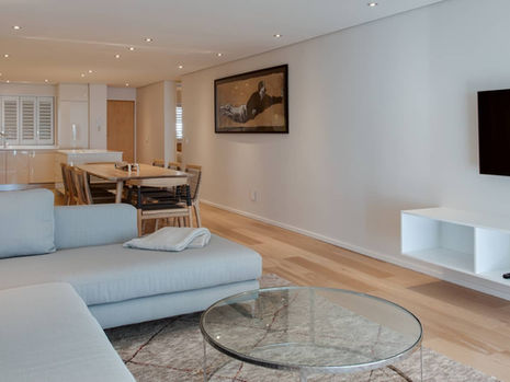 Modern living room with gray sofa and glass table.